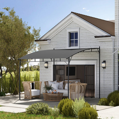 Outdoor patio area with a pergola and furniture in front of a house.